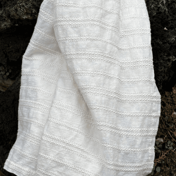 Soft textured blanket draped on a natural stone surface